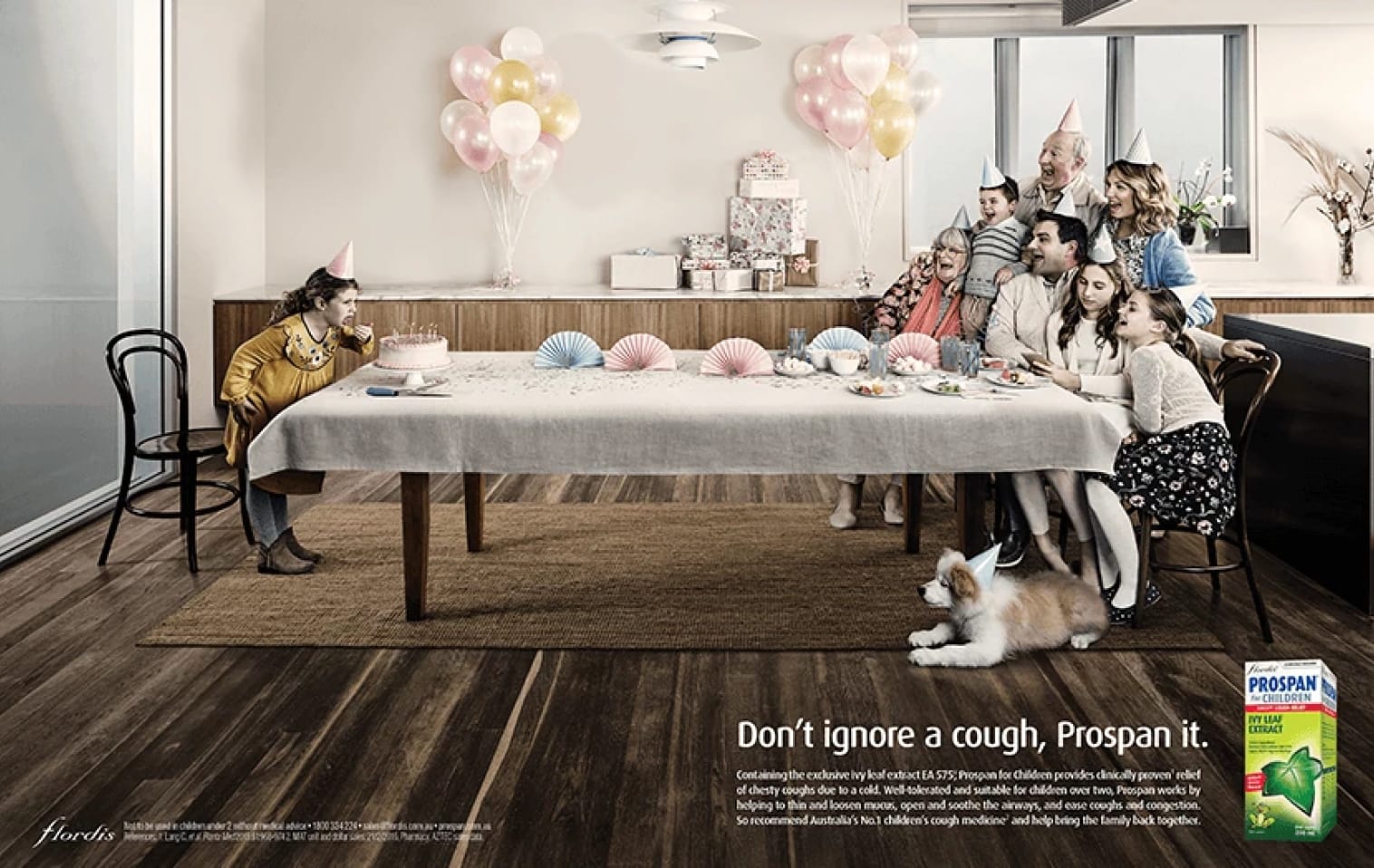 An advert for Prospan depicting a young girl blowing out her birthday candles as her family cowers at the far end of the family dining table because she has a cold.